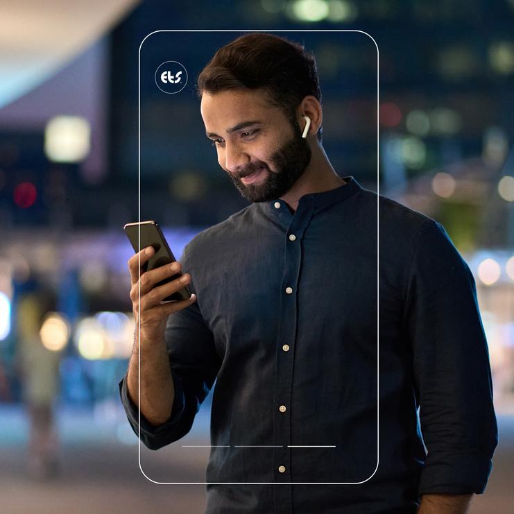 Junger Mann schaut auf sein Smartphone mit den Lichtern einer Stadt im Hintergrund